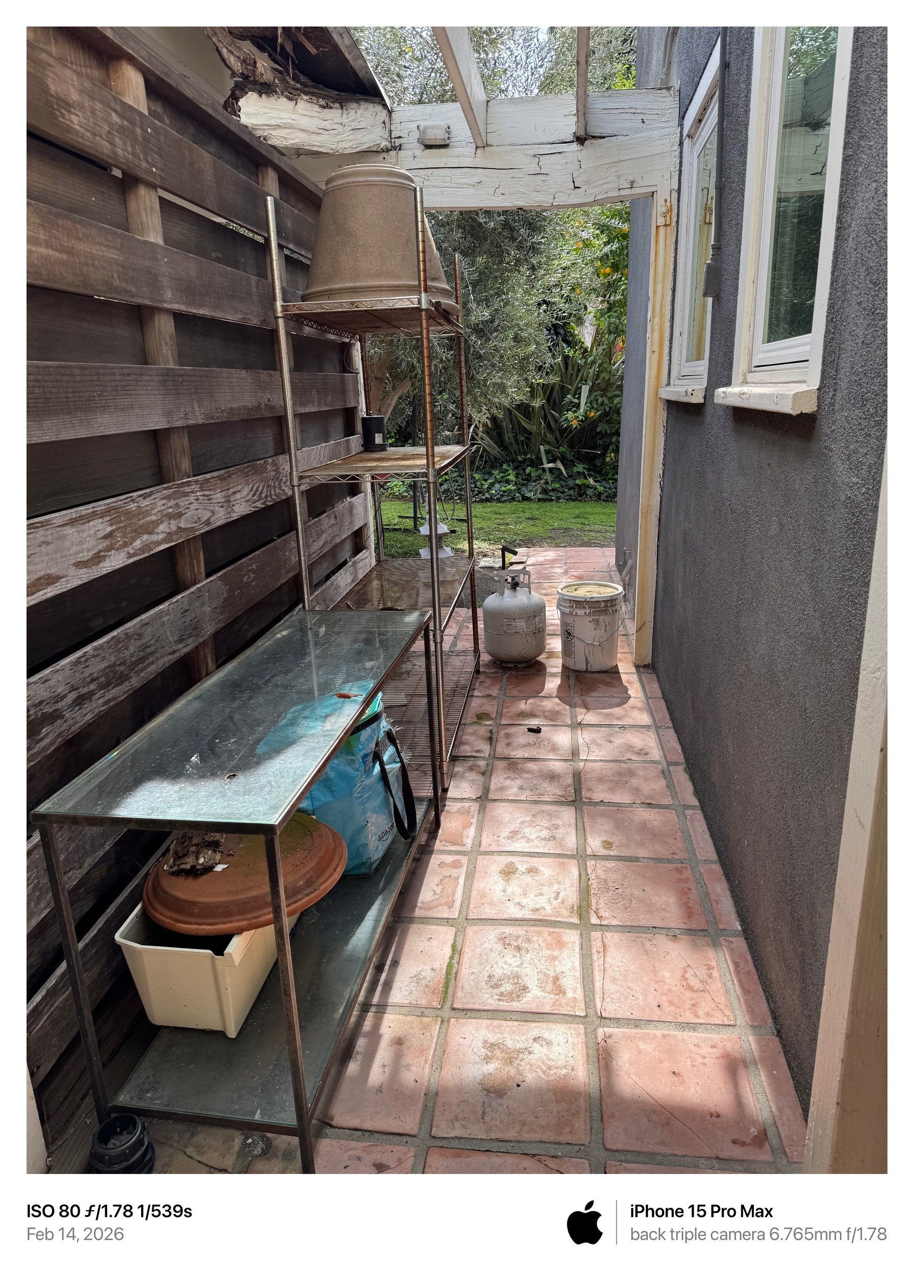 February 14, 2026 photograph showing a propane cylinder and large bucket in the narrow passage