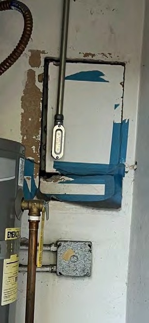 Close-up photograph of the taped electrical area beside the washer and dryer